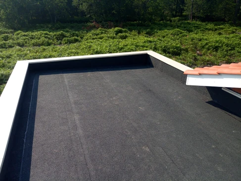 Chantier extérieur d'étanchéité avec ouvriers en combinaisons de protection appliquant membrane bitumineuse au chalumeau
