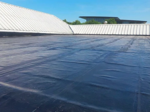 Toiture-terrasse commerciale en membrane EPDM noire avec joints d'étanchéité visibles