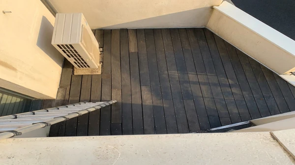 Terrasse couverte moderne avec salon de jardin métallique gris sur plancher bois